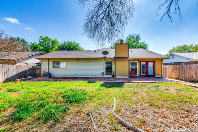 rear view of property featuring a lawn, a patio area, and central AC