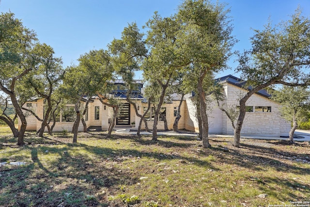 view of front of home with a patio and a front yard