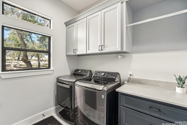 clothes washing area with cabinets and independent washer and dryer