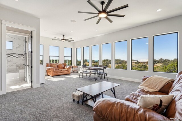 carpeted living room with ceiling fan