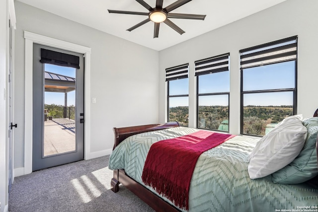 carpeted bedroom featuring access to outside, multiple windows, and ceiling fan