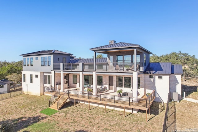 back of house featuring a lawn, ceiling fan, a balcony, and an outdoor hangout area