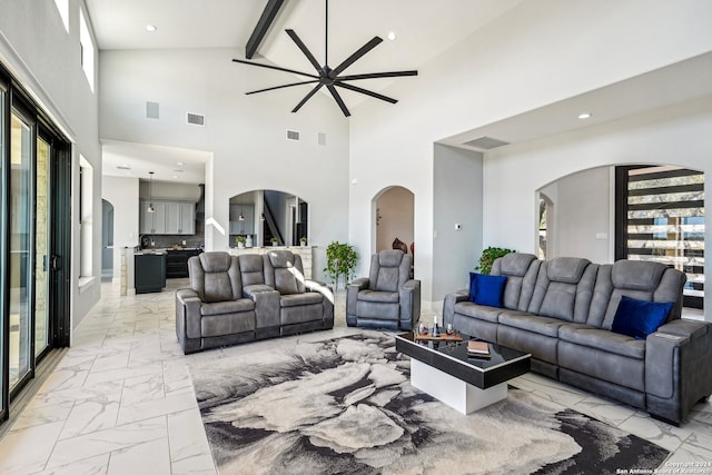 living room with a wealth of natural light, beamed ceiling, and high vaulted ceiling