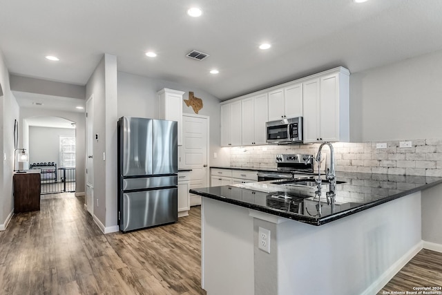 kitchen featuring kitchen peninsula, appliances with stainless steel finishes, sink, light hardwood / wood-style flooring, and white cabinetry