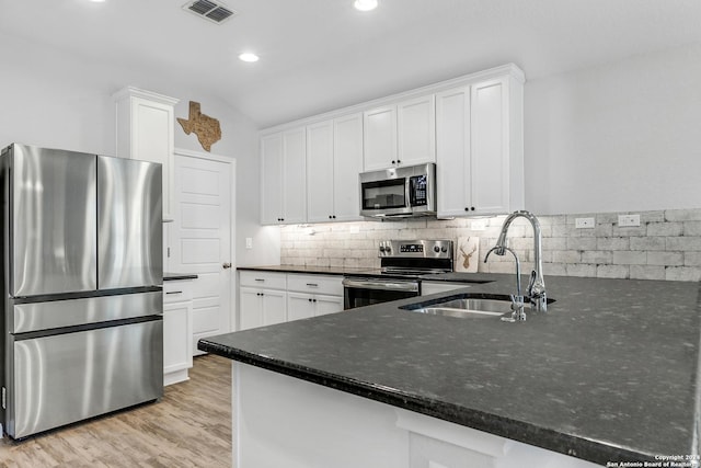 kitchen with kitchen peninsula, white cabinetry, sink, and appliances with stainless steel finishes