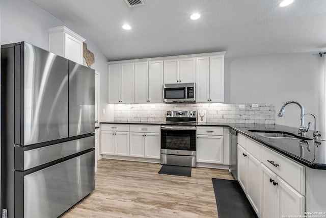 kitchen with white cabinetry, sink, appliances with stainless steel finishes, and light hardwood / wood-style flooring