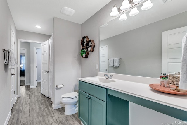 bathroom with hardwood / wood-style floors, vanity, and toilet