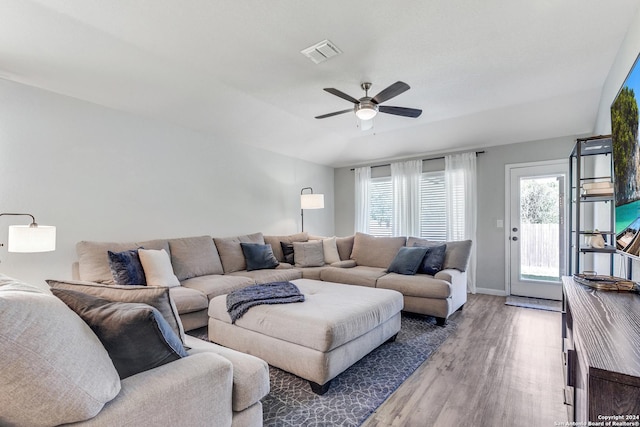 living room featuring ceiling fan and dark hardwood / wood-style floors