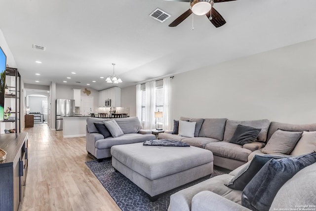 living room with ceiling fan with notable chandelier and light hardwood / wood-style floors