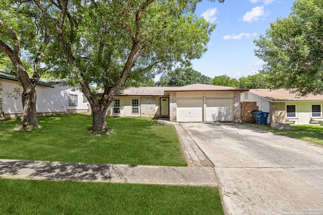 single story home featuring a garage and a front lawn