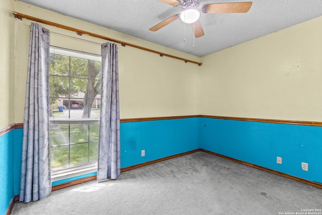 spare room with ceiling fan, light colored carpet, and a textured ceiling