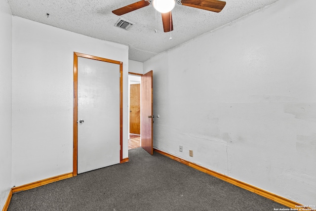 carpeted empty room featuring ceiling fan and a textured ceiling