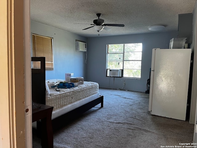 carpeted bedroom with cooling unit, an AC wall unit, ceiling fan, a textured ceiling, and white fridge