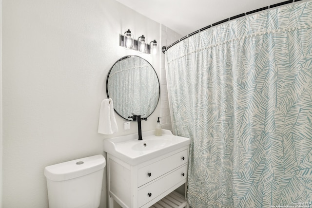 bathroom featuring vanity, curtained shower, and toilet