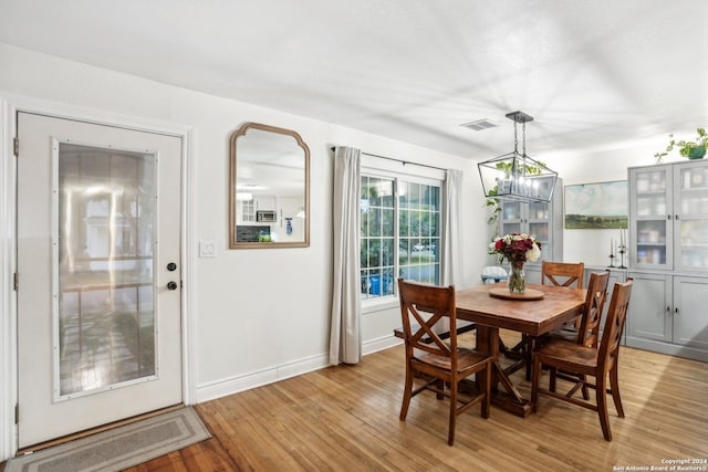 dining space with a notable chandelier and light hardwood / wood-style flooring