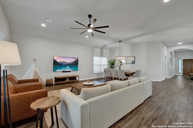 living room featuring wood-type flooring and ceiling fan with notable chandelier