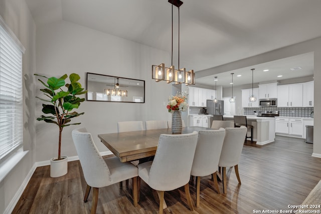 dining space featuring dark hardwood / wood-style flooring and vaulted ceiling