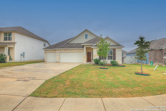 craftsman inspired home featuring a garage and a front lawn