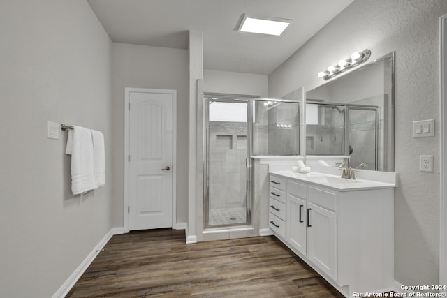 bathroom with hardwood / wood-style floors, vanity, and walk in shower