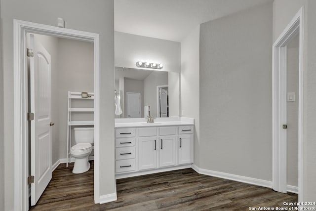 bathroom with toilet, vanity, and hardwood / wood-style flooring