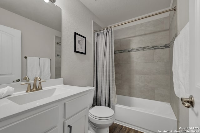 full bathroom with hardwood / wood-style floors, vanity, shower / bath combination with curtain, toilet, and a textured ceiling