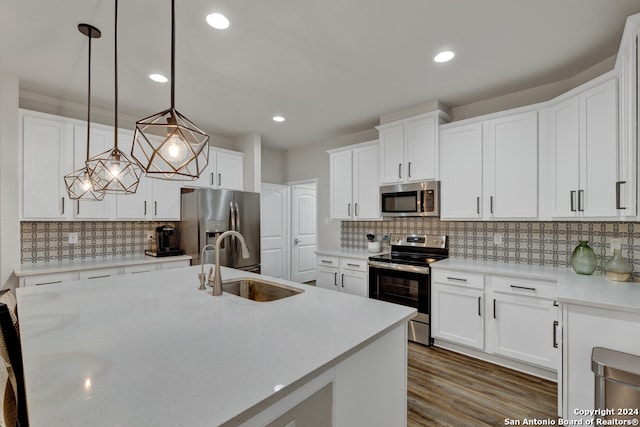 kitchen featuring appliances with stainless steel finishes, white cabinetry, pendant lighting, and sink