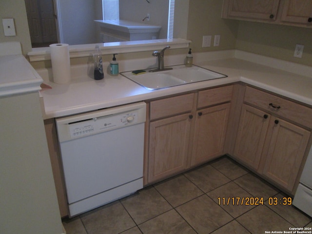 kitchen featuring sink, kitchen peninsula, white dishwasher, light brown cabinetry, and light tile patterned floors