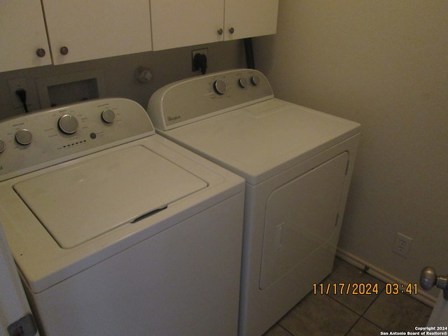 laundry room featuring washer and clothes dryer, cabinets, and tile patterned floors