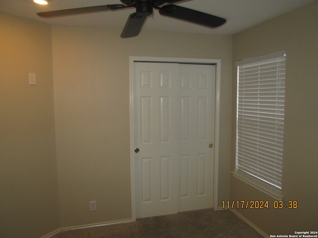 unfurnished bedroom featuring carpet, a closet, and ceiling fan