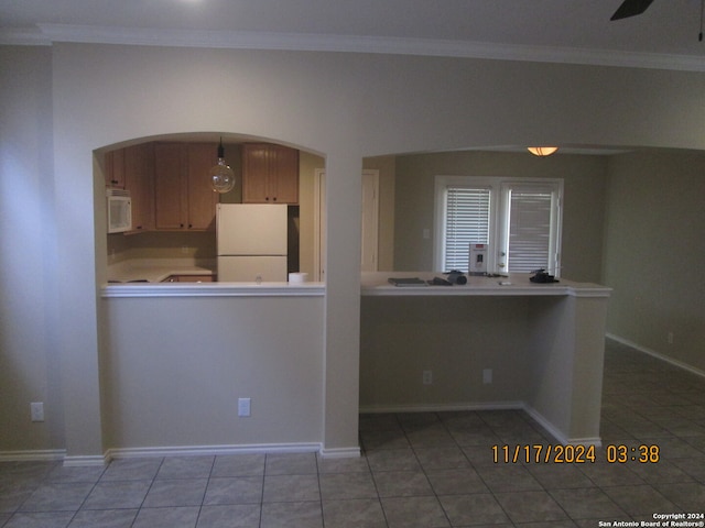 kitchen featuring crown molding, light tile patterned floors, and white appliances