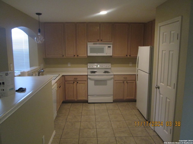 kitchen featuring white appliances, sink, hanging light fixtures, light tile patterned flooring, and kitchen peninsula