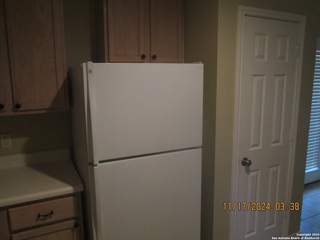 kitchen with tile patterned flooring and white refrigerator