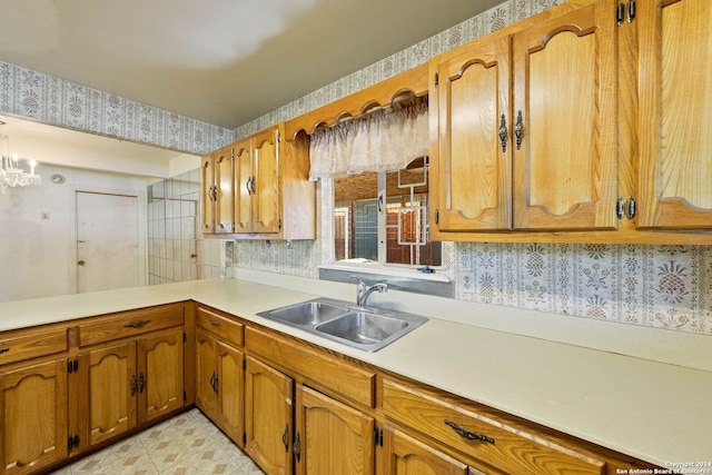 kitchen featuring a chandelier, kitchen peninsula, and sink