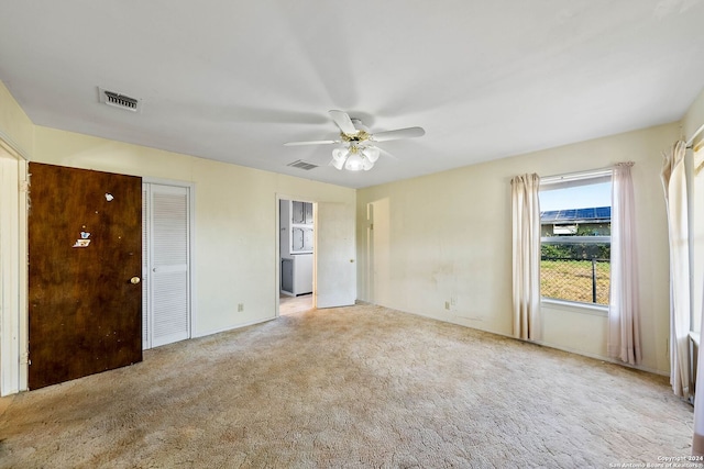 carpeted spare room featuring ceiling fan