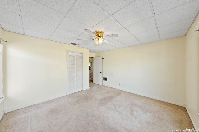 unfurnished room featuring light carpet, a drop ceiling, and ceiling fan