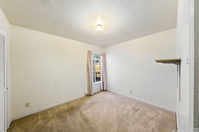 unfurnished bedroom featuring light carpet and a closet