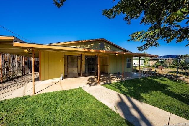 rear view of property featuring a lawn and a patio area