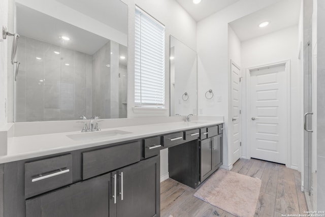 bathroom featuring walk in shower, vanity, and hardwood / wood-style flooring