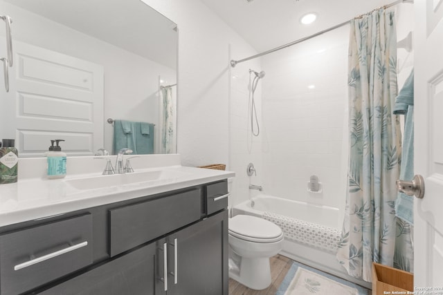 full bathroom featuring toilet, hardwood / wood-style floors, vanity, and shower / tub combo with curtain