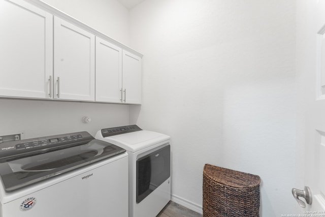 laundry area with hardwood / wood-style flooring, cabinets, and separate washer and dryer