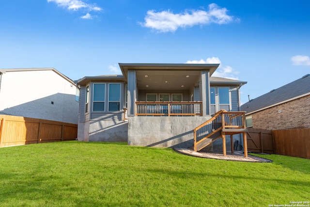 rear view of property featuring a lawn