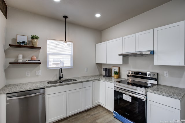 kitchen with stainless steel appliances, sink, decorative light fixtures, light hardwood / wood-style floors, and white cabinetry