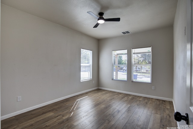 spare room featuring ceiling fan and dark wood-type flooring