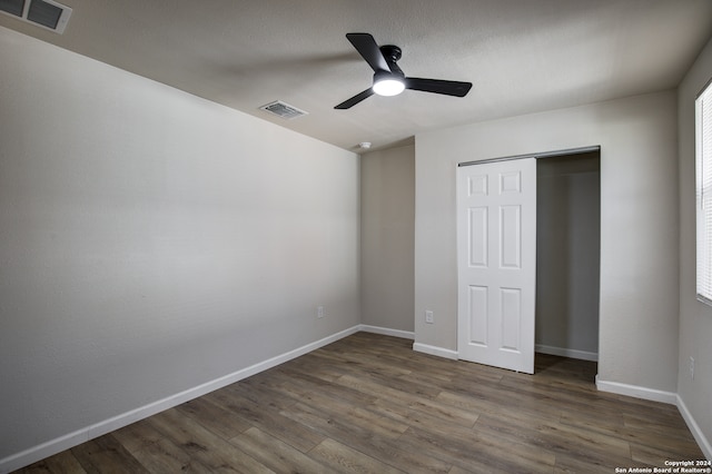 unfurnished bedroom with wood-type flooring, a closet, and ceiling fan