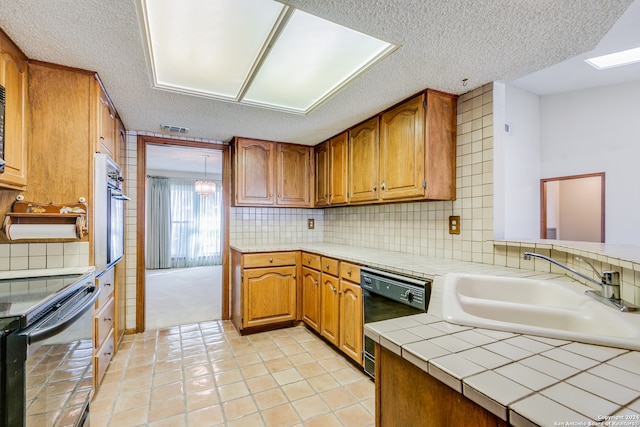 kitchen featuring sink, backsplash, a textured ceiling, light tile patterned flooring, and black appliances