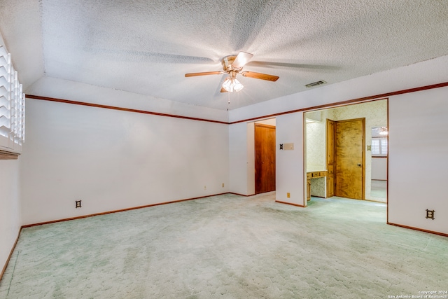 carpeted spare room featuring a textured ceiling, ceiling fan, and lofted ceiling