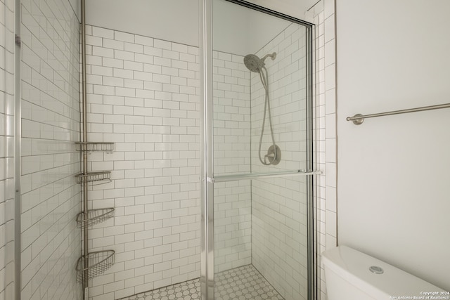 bathroom with toilet and an enclosed shower