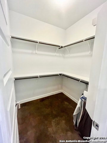 walk in closet with dark carpet