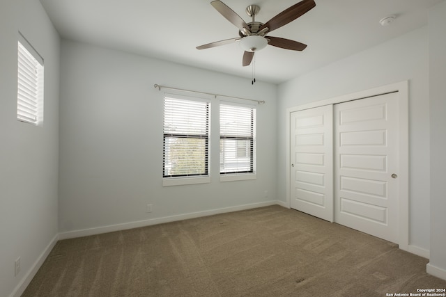 unfurnished bedroom with ceiling fan, carpet floors, and a closet