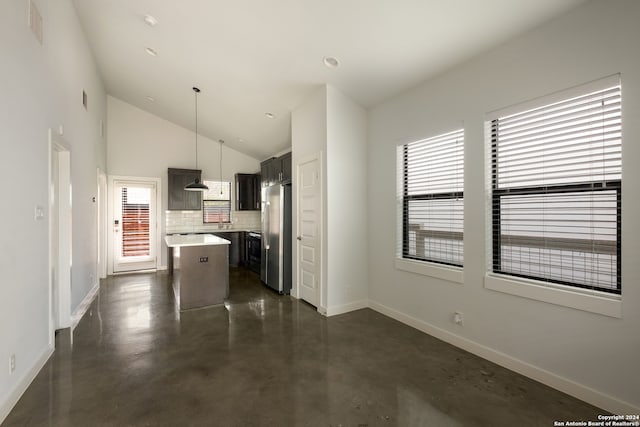 kitchen with a center island, decorative light fixtures, stainless steel refrigerator, and plenty of natural light